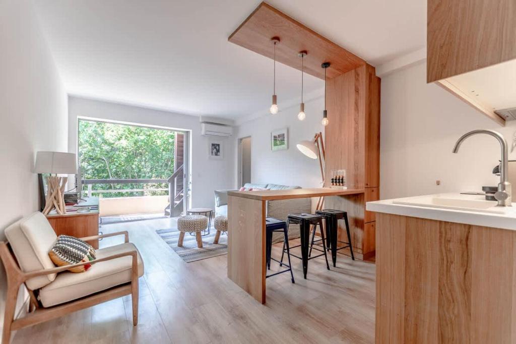une cuisine et un salon avec une table et des chaises dans l'établissement Le Bailly l Beachside & Rooftop l Shellter Rentals, à Saint-Tropez