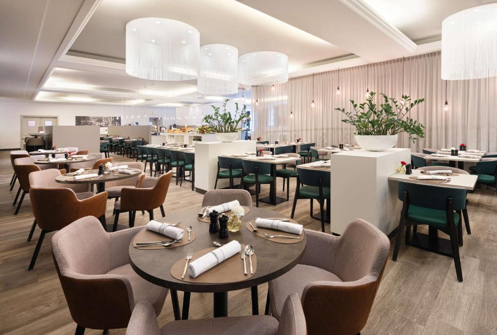 een eetkamer met tafels en stoelen en een restaurant bij NH Collection Gent in Gent