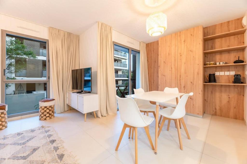 un salon avec une table, des chaises et une télévision dans l'établissement Studio Résistance l Central l Shellter Rentals, à Saint-Tropez