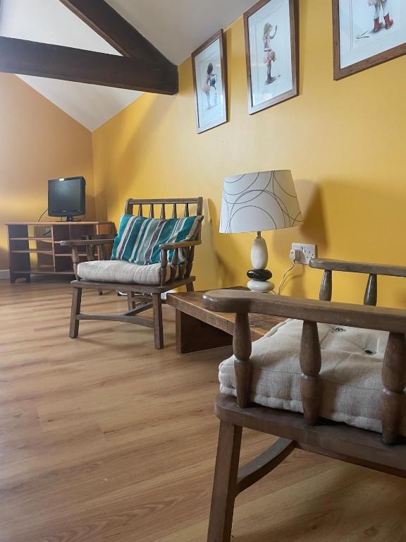 a living room with two chairs and a table at Ye Old Sun Inn, Barn Studio in Bilbrough