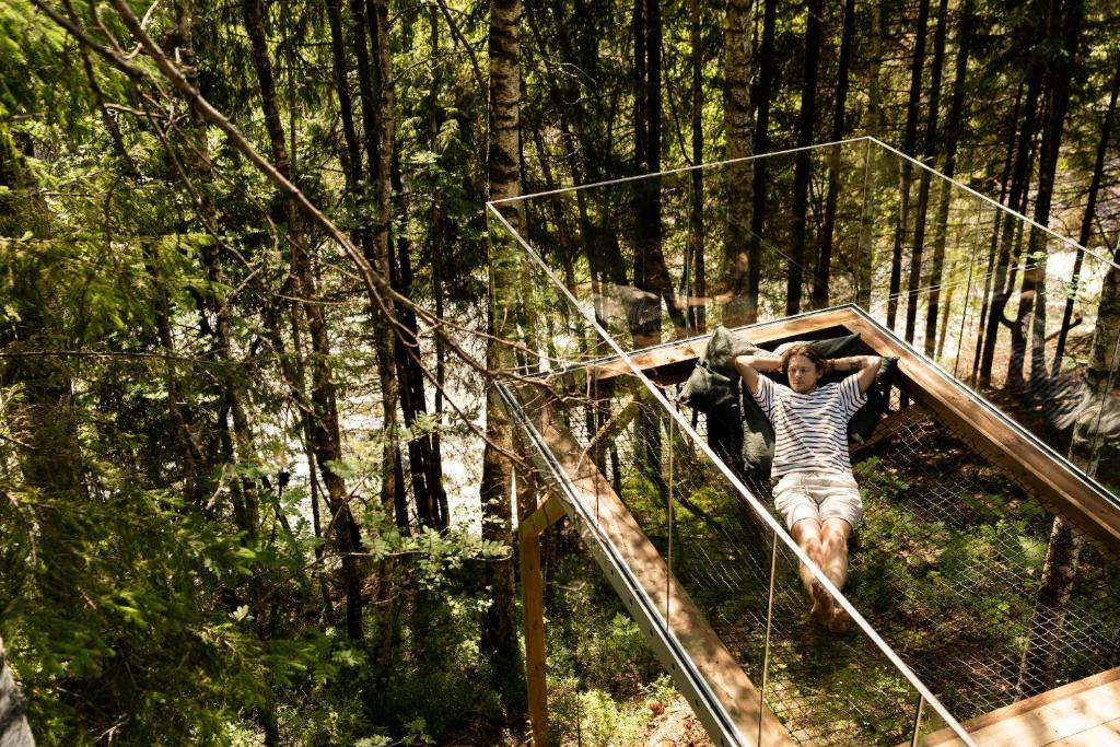 Una mujer caminando por un puente en un bosque en Laagen, en Steinsholt