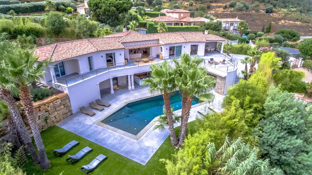 - une vue aérienne sur une maison avec une piscine et des palmiers dans l'établissement Magnificent villa, heated pool, air cond, sea view, à Sainte-Maxime