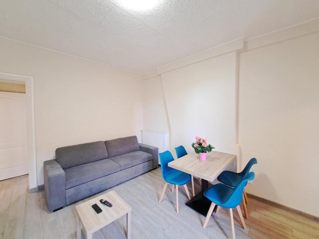 un salon avec un canapé, une table et des chaises dans l'établissement El Dorado - Proche du centre-ville, à Reims