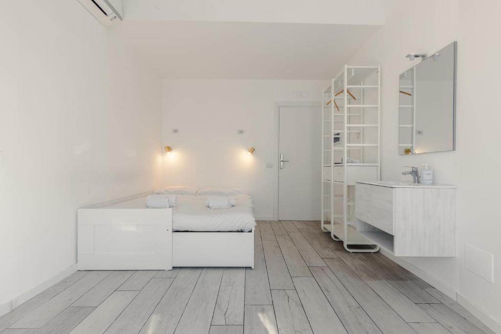 a white room with a bed and a sink at My Tiny Home in Rome