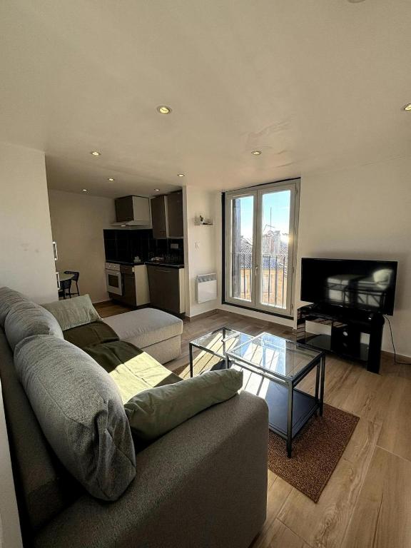 un salon avec un canapé et une table en verre dans l'établissement F2 Toits Ecusson 4 pers. Eglise St Anne 5 min Com, à Montpellier