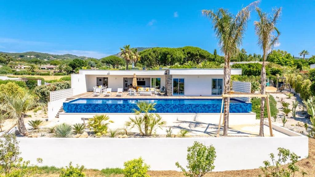une maison avec une piscine et des palmiers dans l'établissement Villa Palm Dreams l 70s Design l Shellter Rentals, à Grimaud