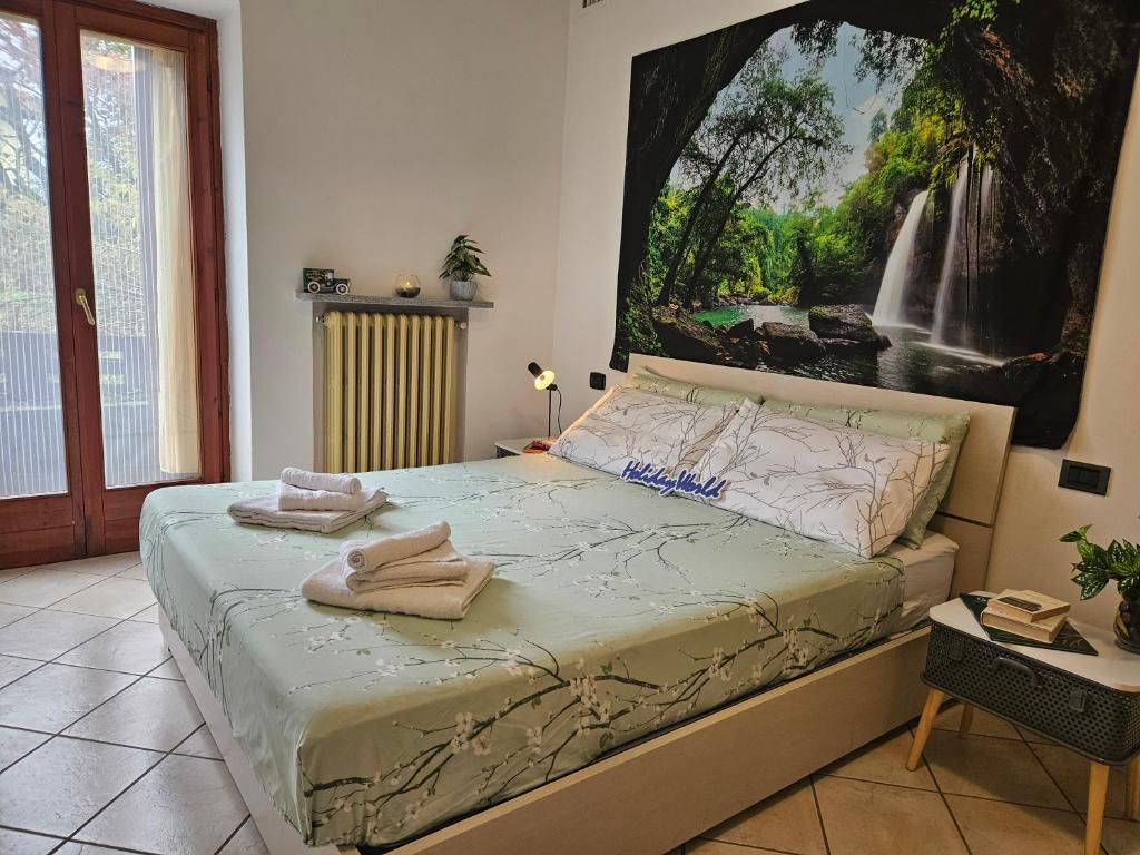 a bedroom with a bed with a painting on the wall at Il Riposo del Viaggiatore by Holiday World in Ternate