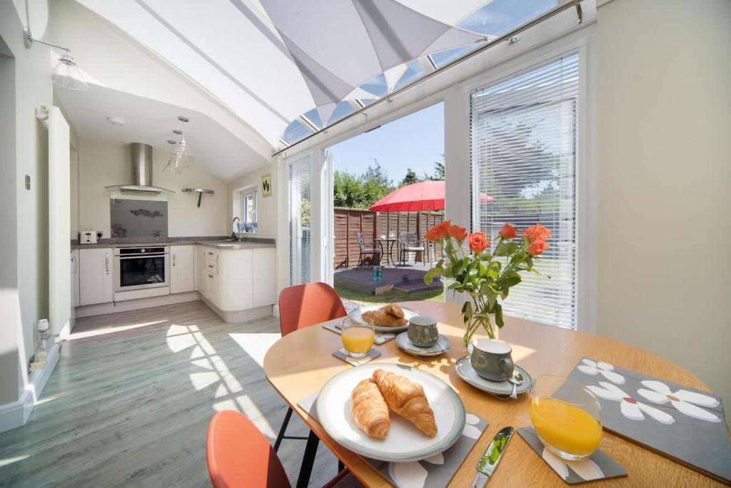 a kitchen and dining room with a table with bread on it at Skysail, Gurnard in Gurnard