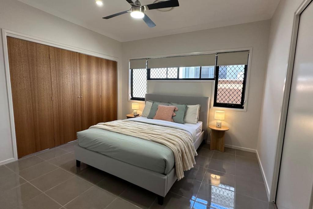 Sienna Rise - Walk to Westfield sleeps 6 North Lakes في البحيرات الشمالية: غرفة نوم بها سرير ومروحة سقف