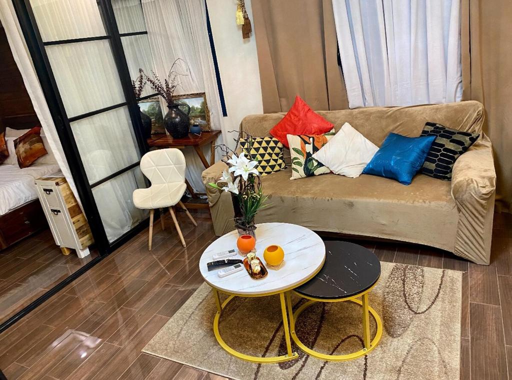 マニラにあるAir Residence T1 Amazing Makati Luxury Condo 66 sq m 300Mbps Fastのソファとテーブルのあるリビングルーム