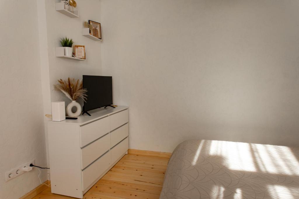 a bedroom with a bed and a tv on a dresser at Parka ielas apartamenti in Alūksne