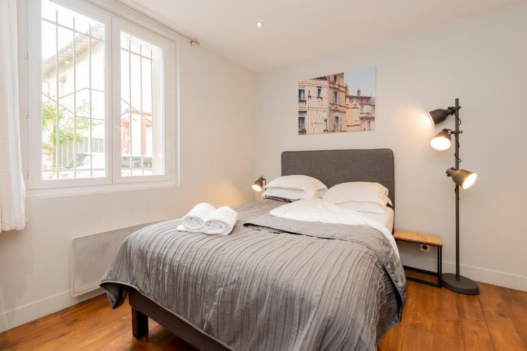 une chambre avec un lit avec deux serviettes dessus dans l'établissement Le Boubée - Studio proche gare, à Toulouse