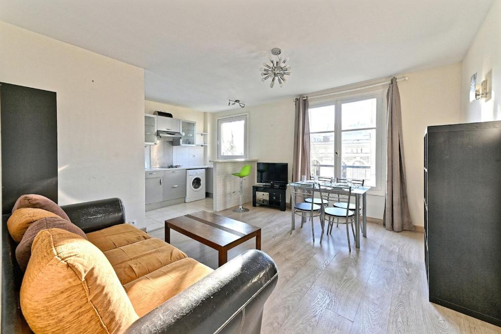 un salon avec un canapé et une table dans l'établissement Appartement Central Avenue du Maine - III, à Paris