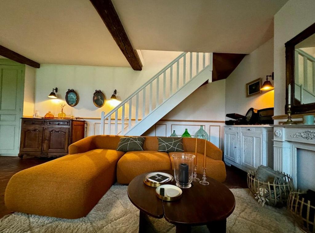 - un salon avec un grand canapé et un escalier dans l'établissement La Maison de Passy, à Passy