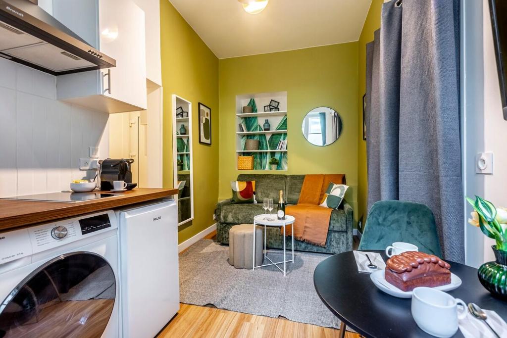 d'une cuisine et d'un salon avec des murs jaunes et une table. dans l'établissement Studio Opera #Grands Boulevards#Louvre, à Paris