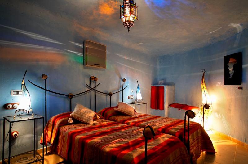 Un dormitorio con una cama grande en una habitación. en Hotel Cueva Tardienta Monegros-Adults Only, en Tardienta