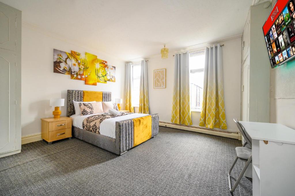 Un dormitorio con una cama, un escritorio y ventanas. en -RC15CFA- For Relaxed and Cosy stay with Free Parking, en Leeds
