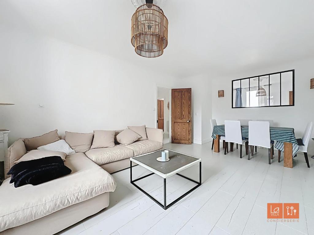 un salon avec un canapé et une table dans l'établissement Wimereux - Appartement 2 chambres proche mer et centre, à Wimereux