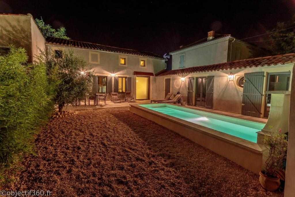 - une piscine dans la cour d'une maison la nuit dans l'établissement Mas provençal au coeur de L'Isle-sur-la-Sorgue, à LʼIsle-sur-la-Sorgue
