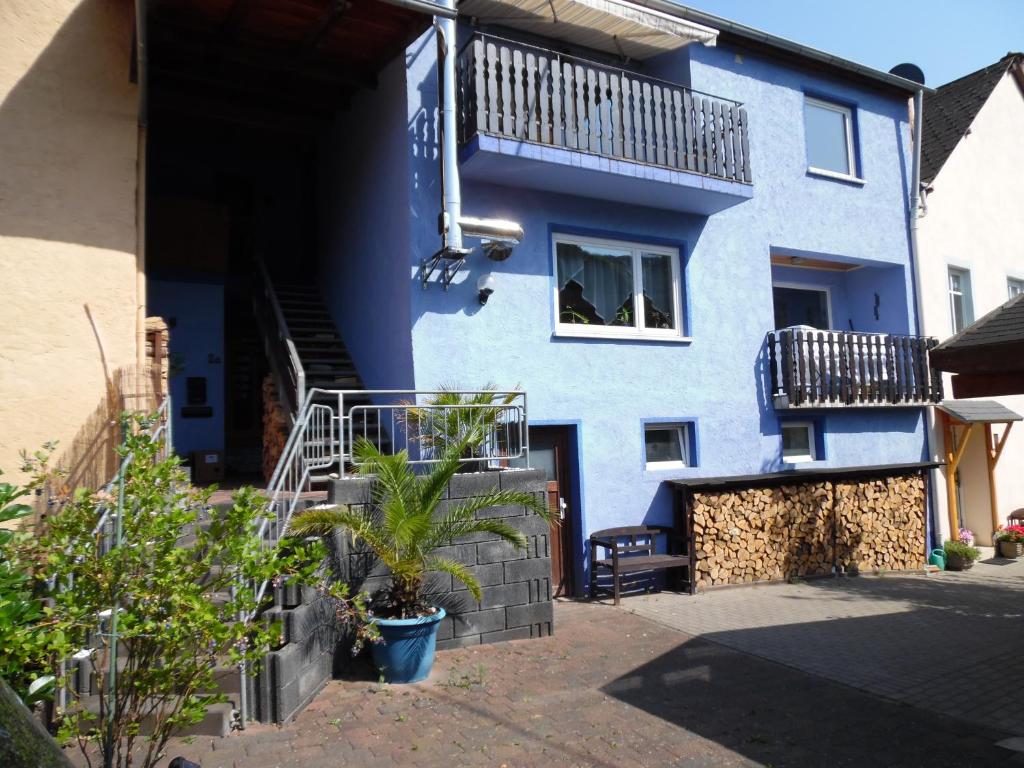 een blauw huis met een trap en een balkon bij Ferienwohnung In Vino Veritas in Neumagen-Dhron