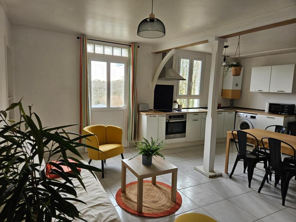a kitchen and living room with a table and chairs at Petite maison 2 chambres Guéret in Guéret