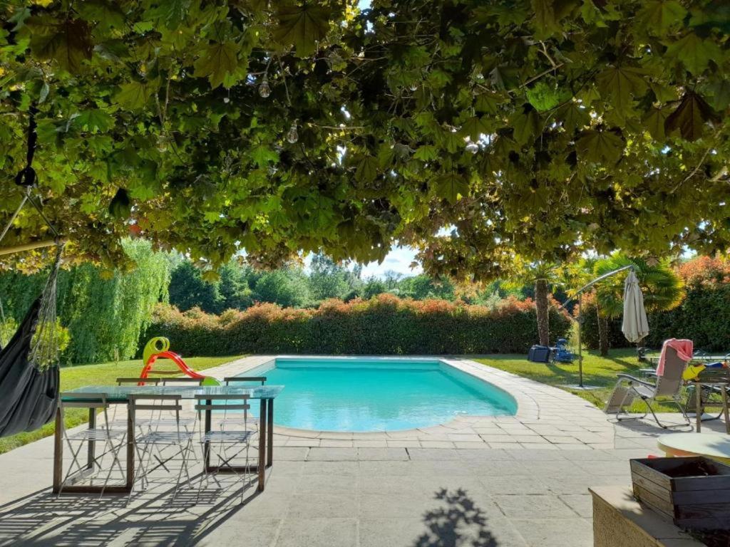 a swimming pool with a table and a playground at Le Moulin du Châtelier in Paulmy