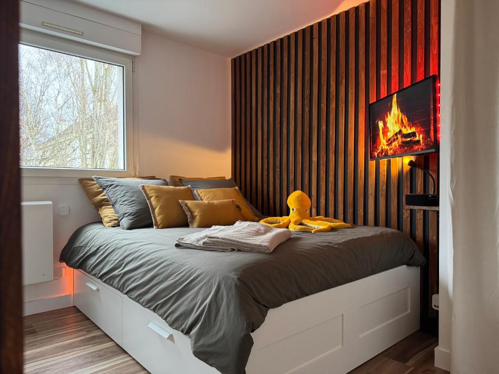 a bedroom with a bed with a fire on the wall at L'Escale - 300 m Océan - Hyper Centre - Lumineux - Garage Privatif in Saint-Nazaire