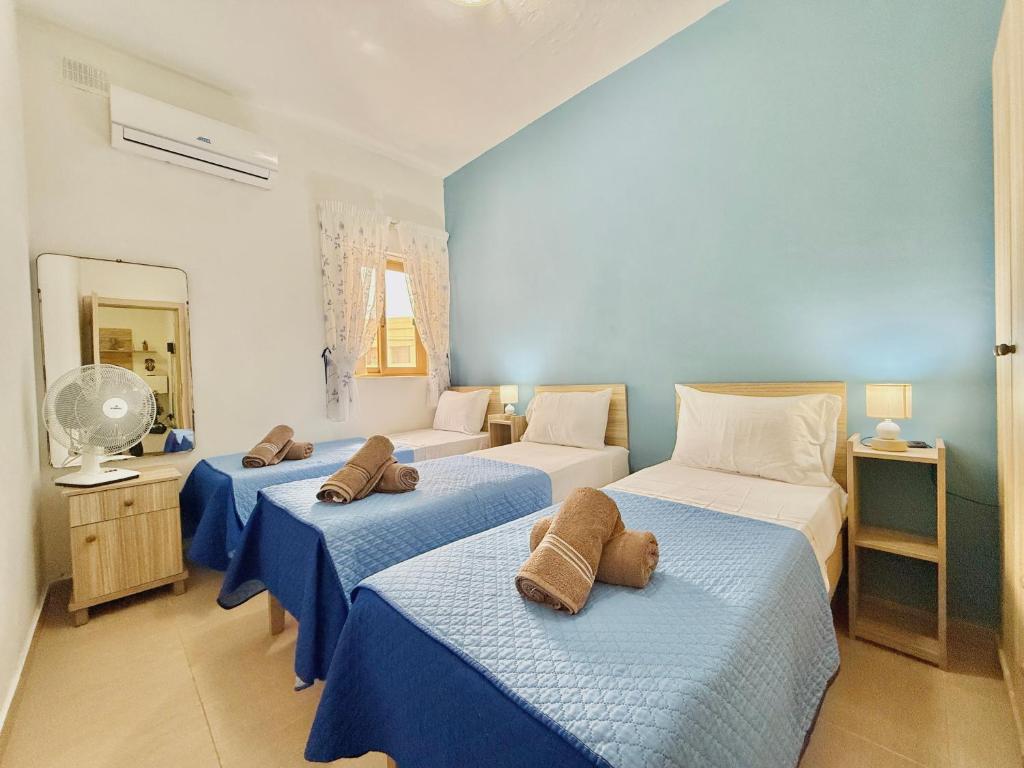 パオーラにあるApartment in South Part Maltaのベッドルーム(青と白のベッド3台付)