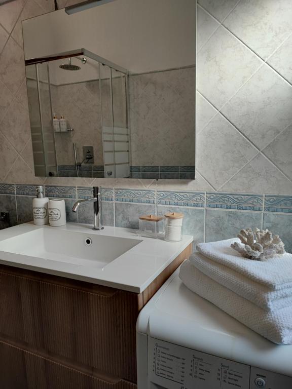 a bathroom with a sink and a mirror at Abba Sixty - View, Pool & Parking - 200mt Sea in Tertenìa