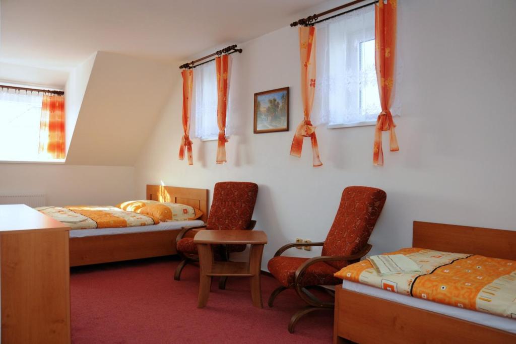 sypialnia z 2 łóżkami, stołem i krzesłami w obiekcie Penzion Rakovec w mieście Bukovinka
