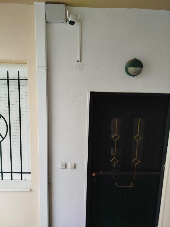 a black door in a room with a window at Comfy Alykes Apartment, Volos in Volos