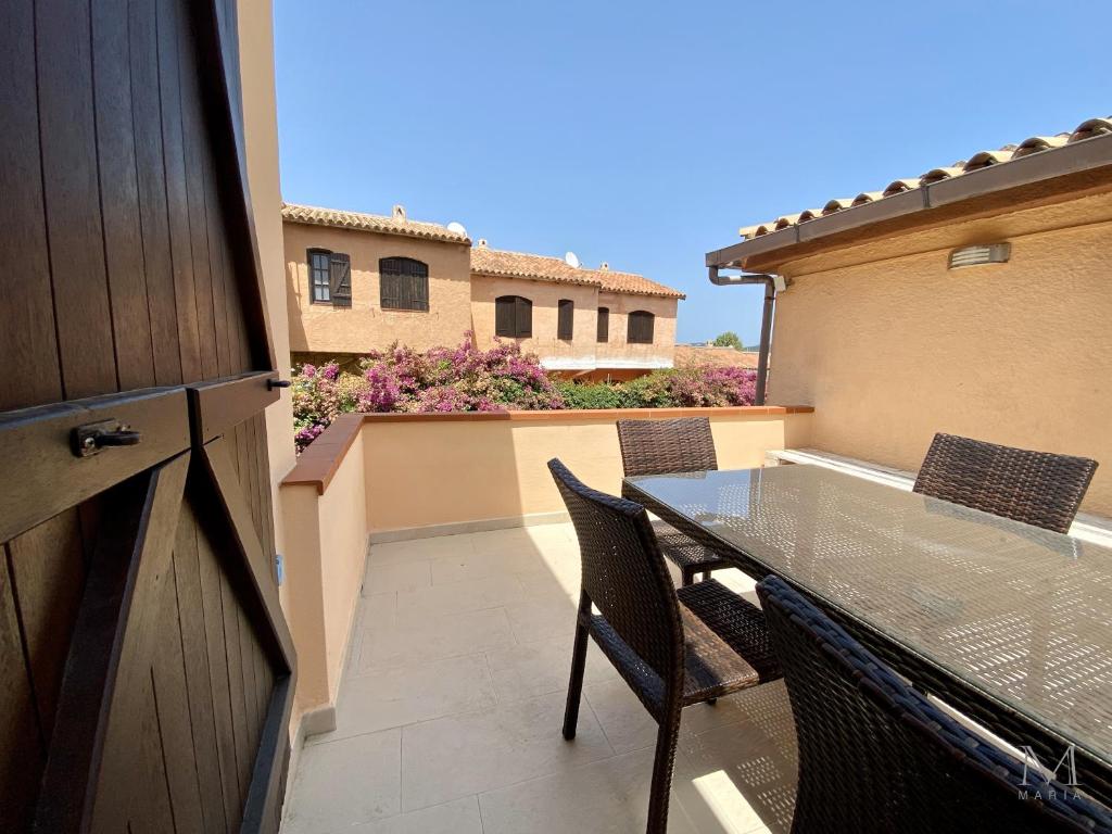 a patio with a glass table and chairs on a balcony at Trilocale sul Lungomare in Cannigione