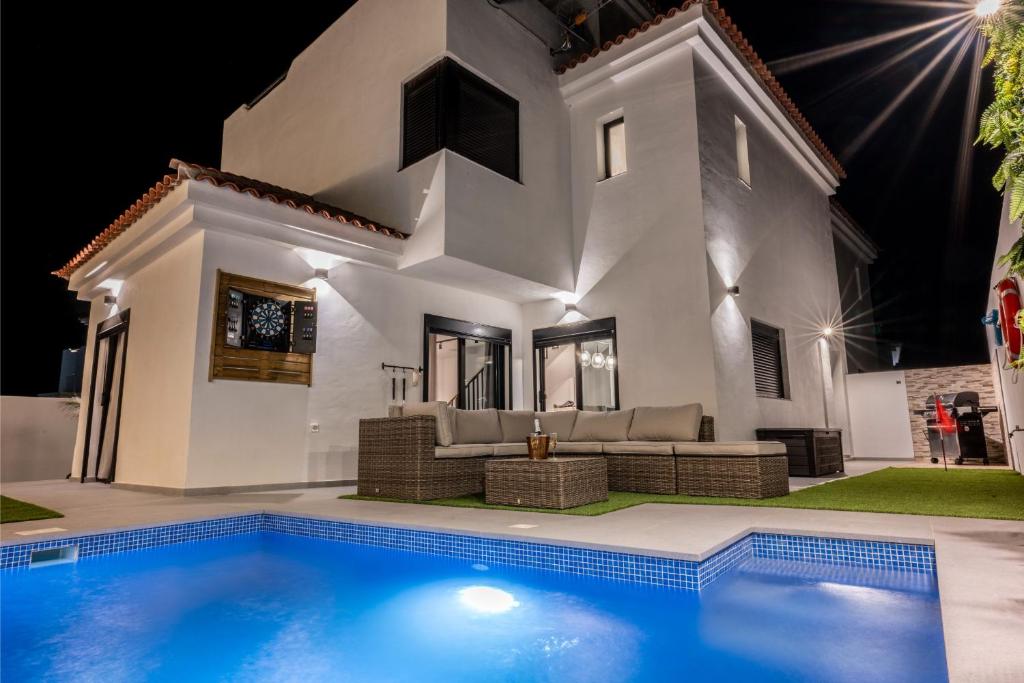 una casa blanca con una piscina delante de ella en Luxury Villa Libellile, en San Miguel de Abona