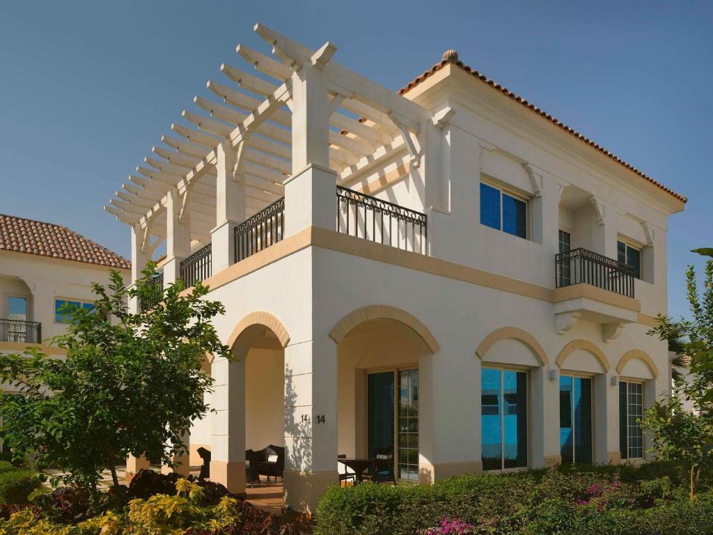 a large white house with a pergola at Move On Beach Resort Al Khobar in Half Moon Bay