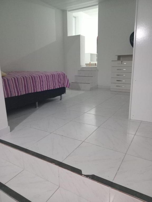 une chambre avec un lit et un sol carrelé dans l'établissement Casa do Sossego, à Ilha do Frade