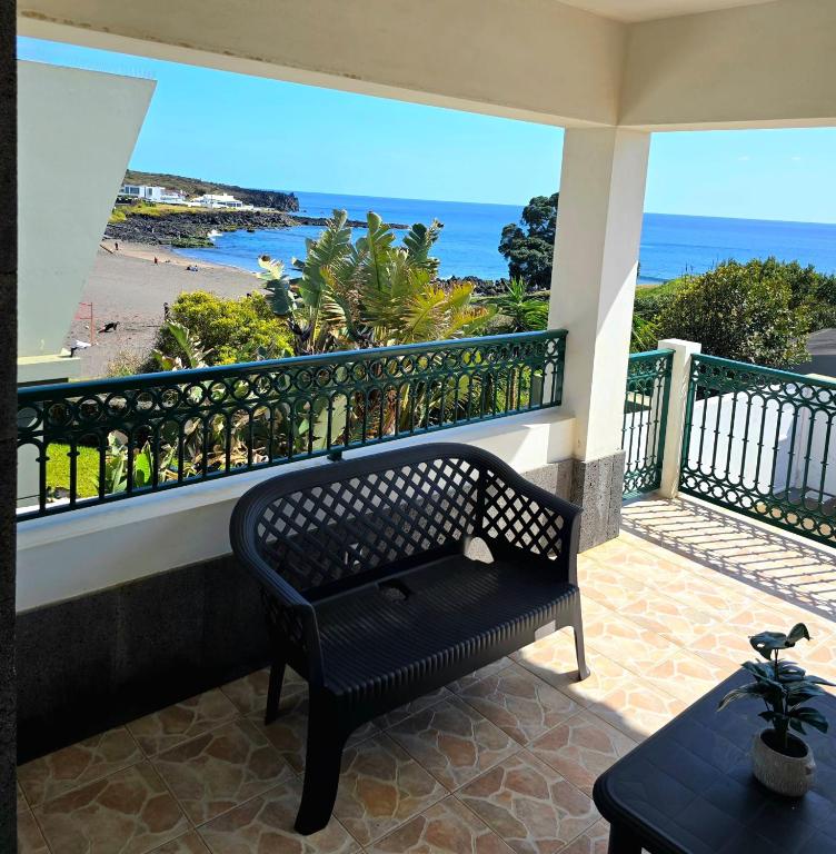 a bench on a balcony with a view of the beach at Ocean Breeze in Ponta Delgada