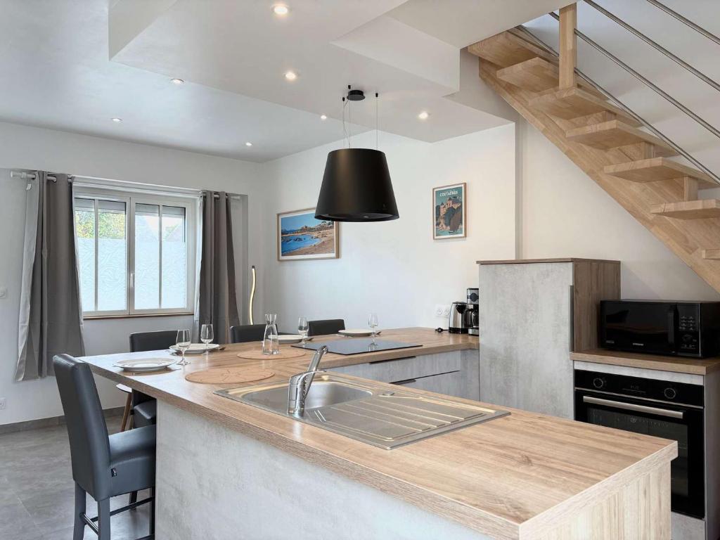 a kitchen with a sink and a counter top at Maison rénovée proche plages de Trégastel - FR-1-542-68 in Trégastel