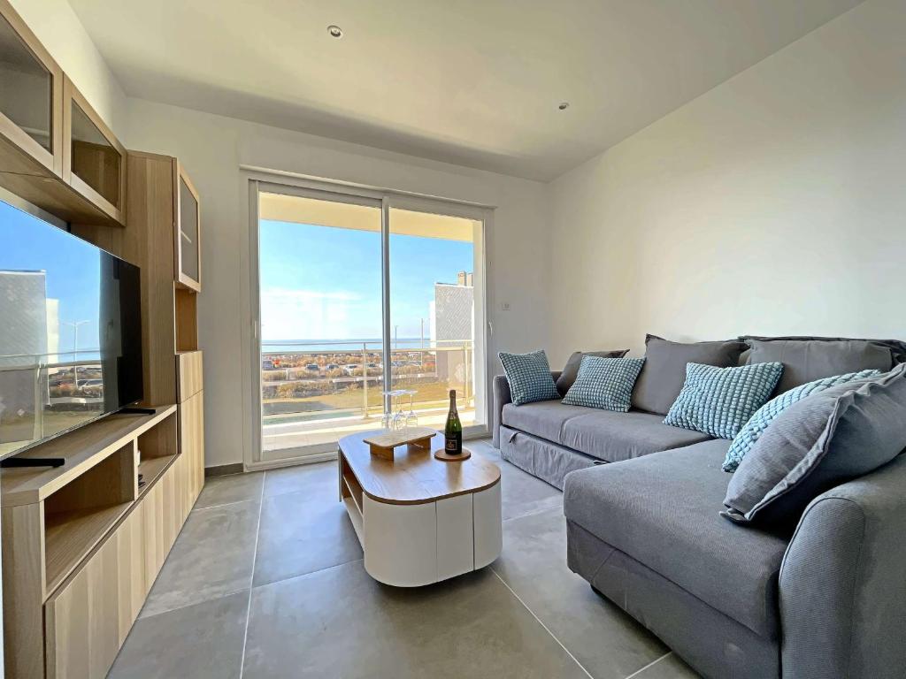 un salon avec un canapé et une télévision dans l'établissement Superbe T3 rénové avec balcon face mer - FR-1-646-86, à Berck-sur-Mer