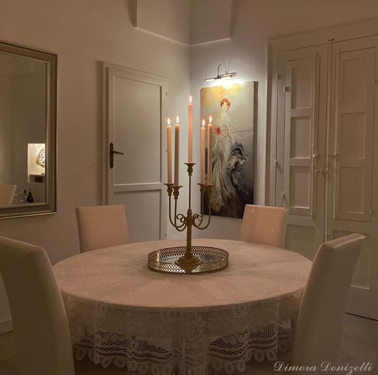 ein Esszimmer mit einem Tisch mit Kerzen darauf in der Unterkunft Dimora Donizetti 5 in Carovigno