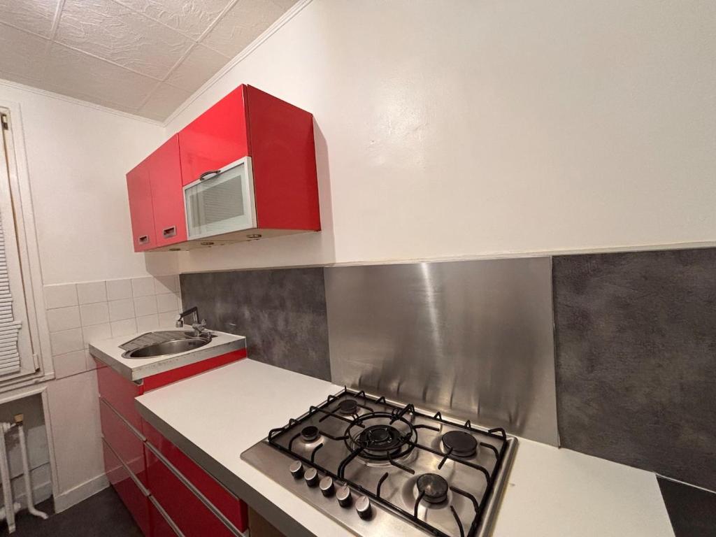 a kitchen with a stove and a microwave at Maison cosy proche gare SNCF 2 chambres in Saint-Pierre-des-Corps