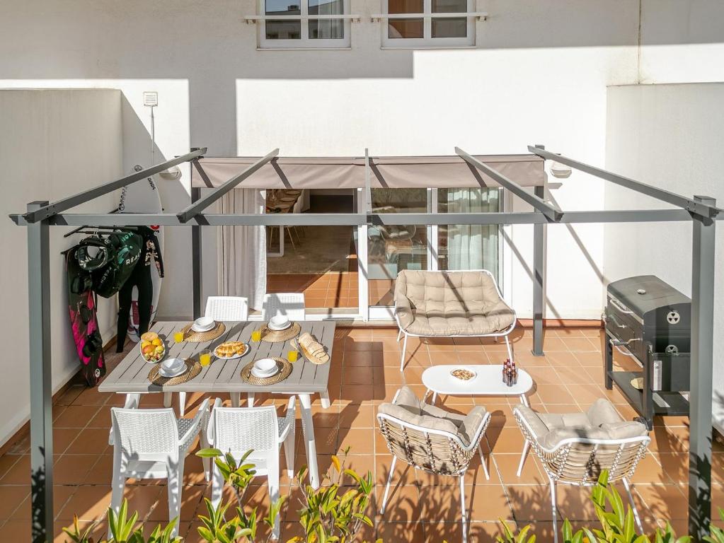 a balcony with a table and chairs and a grill at Seabreeze Duplex – Beach & Terrace in Viana do Castelo