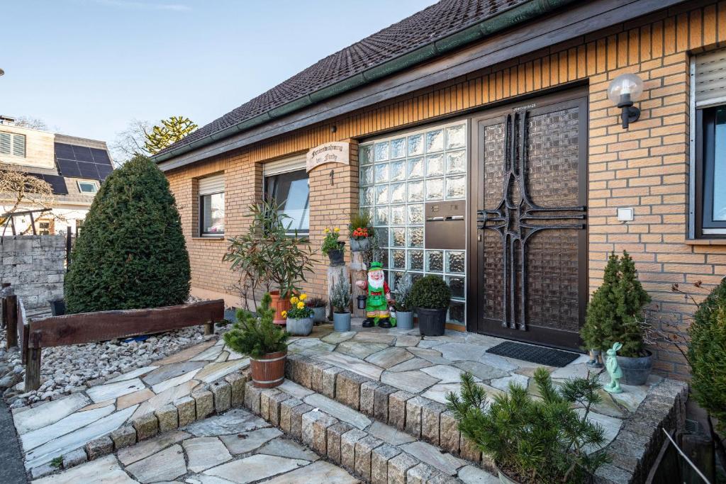 een stenen huis met een houten deur en een bank bij Ferienwohnung bei Fredy in Langenargen