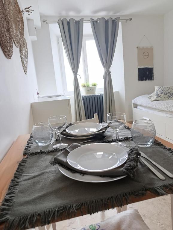 une table de salle à manger avec des assiettes et des verres dessus dans l'établissement Logement le gabian, à Ampus