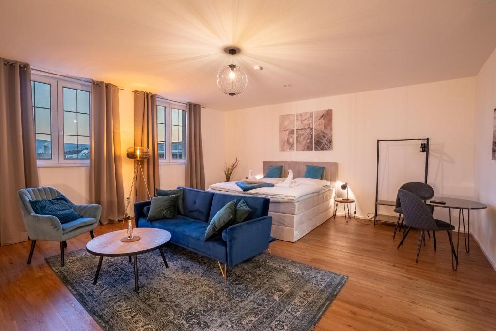 a living room with a bed and a blue couch at Schängel Chic 19 in Koblenz