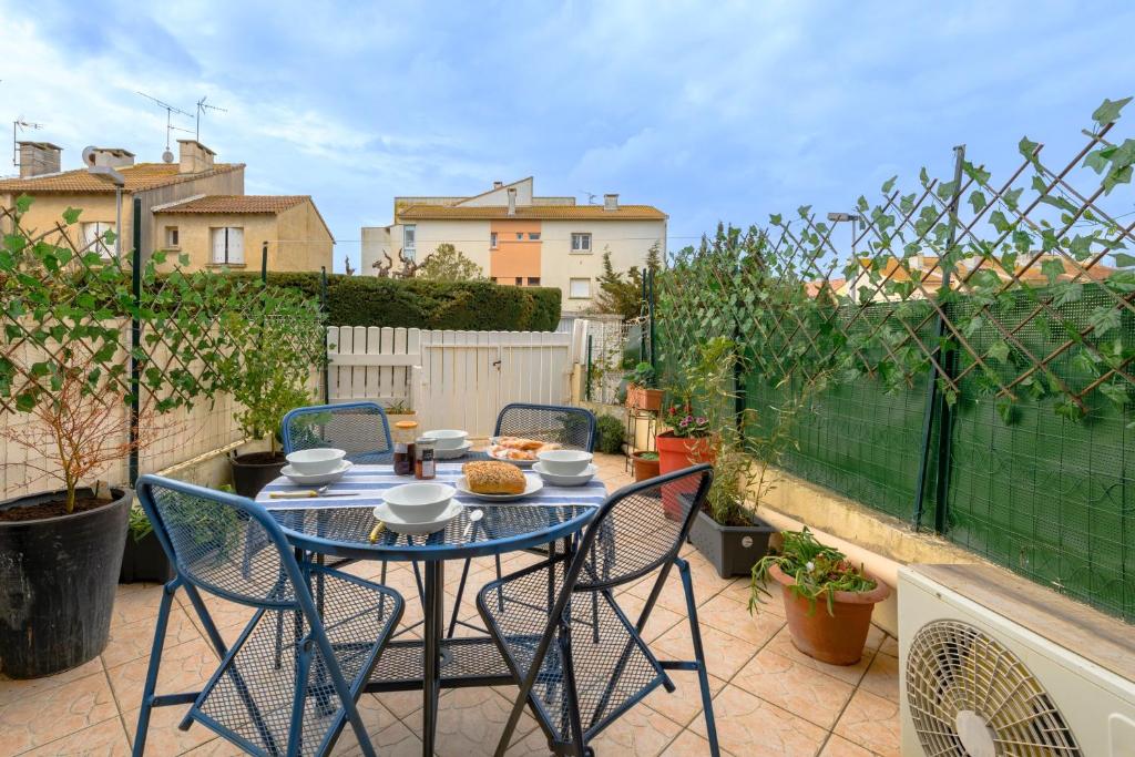un patio avec une table et des chaises sur un balcon dans l'établissement Le Pagnol - Studio proche plage, au Grau-du-Roi