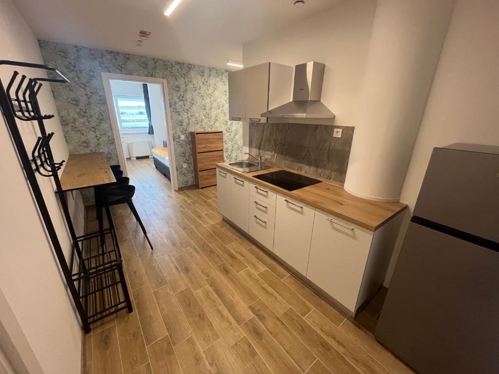 a kitchen with white cabinets and a wooden floor at Motel Barka in Koper