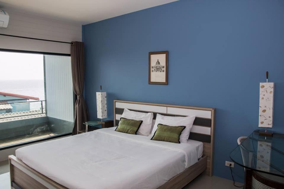 a bedroom with a large bed with a blue wall at Chill Days @ Koh Larn in Ko Larn