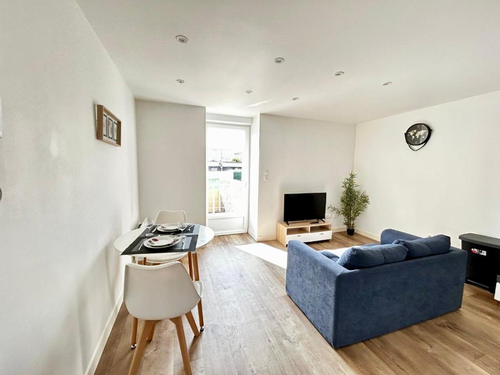 un salon avec un canapé bleu et une table dans l'établissement La Terrazza, cocon avec terrasse, à Limoges