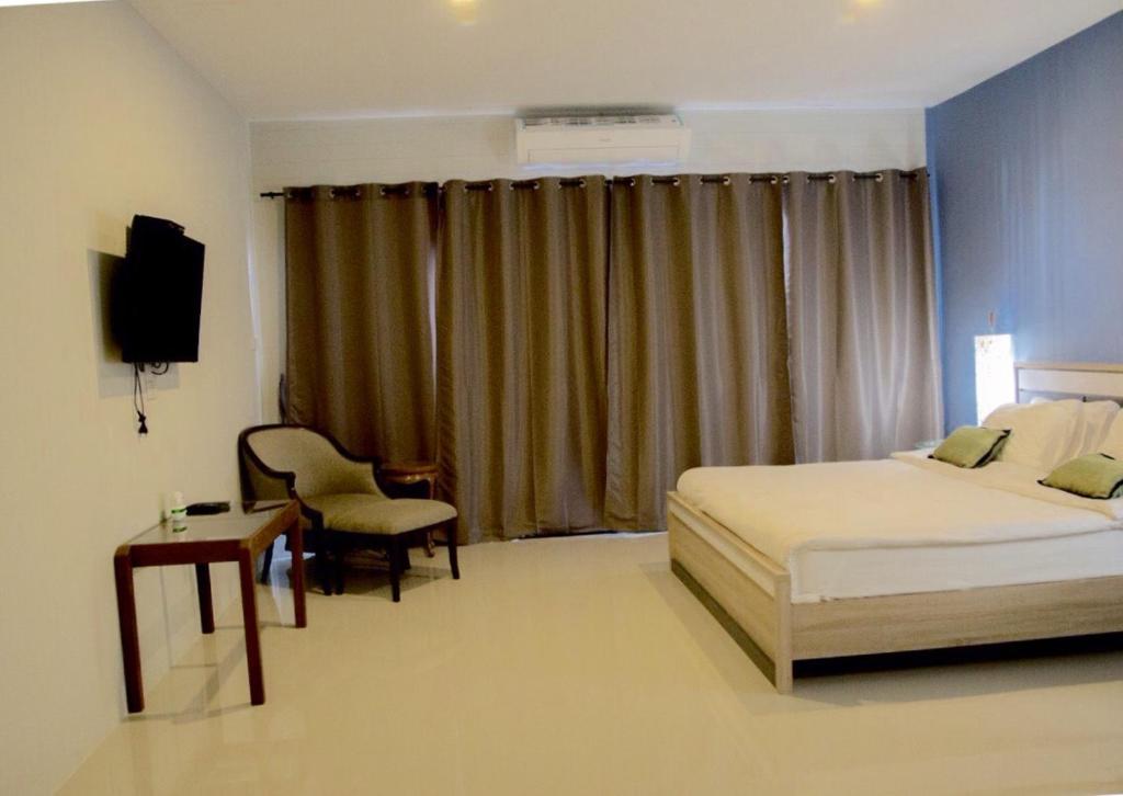 a bedroom with a bed and a desk and a television at Chill Days @ Koh Larn in Ko Larn