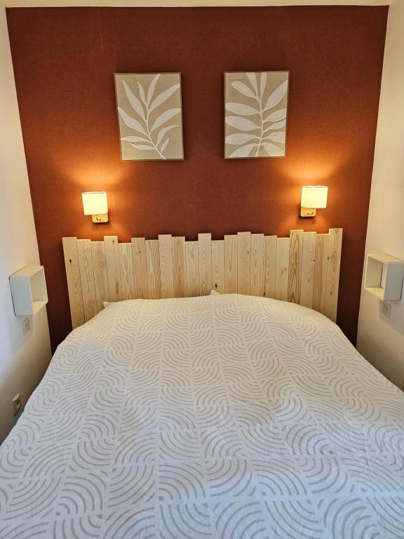 - une chambre avec un grand lit et 2 photos sur le mur dans l'établissement Appartement en résidence avec piscine, à Le Touquet-Paris-Plage